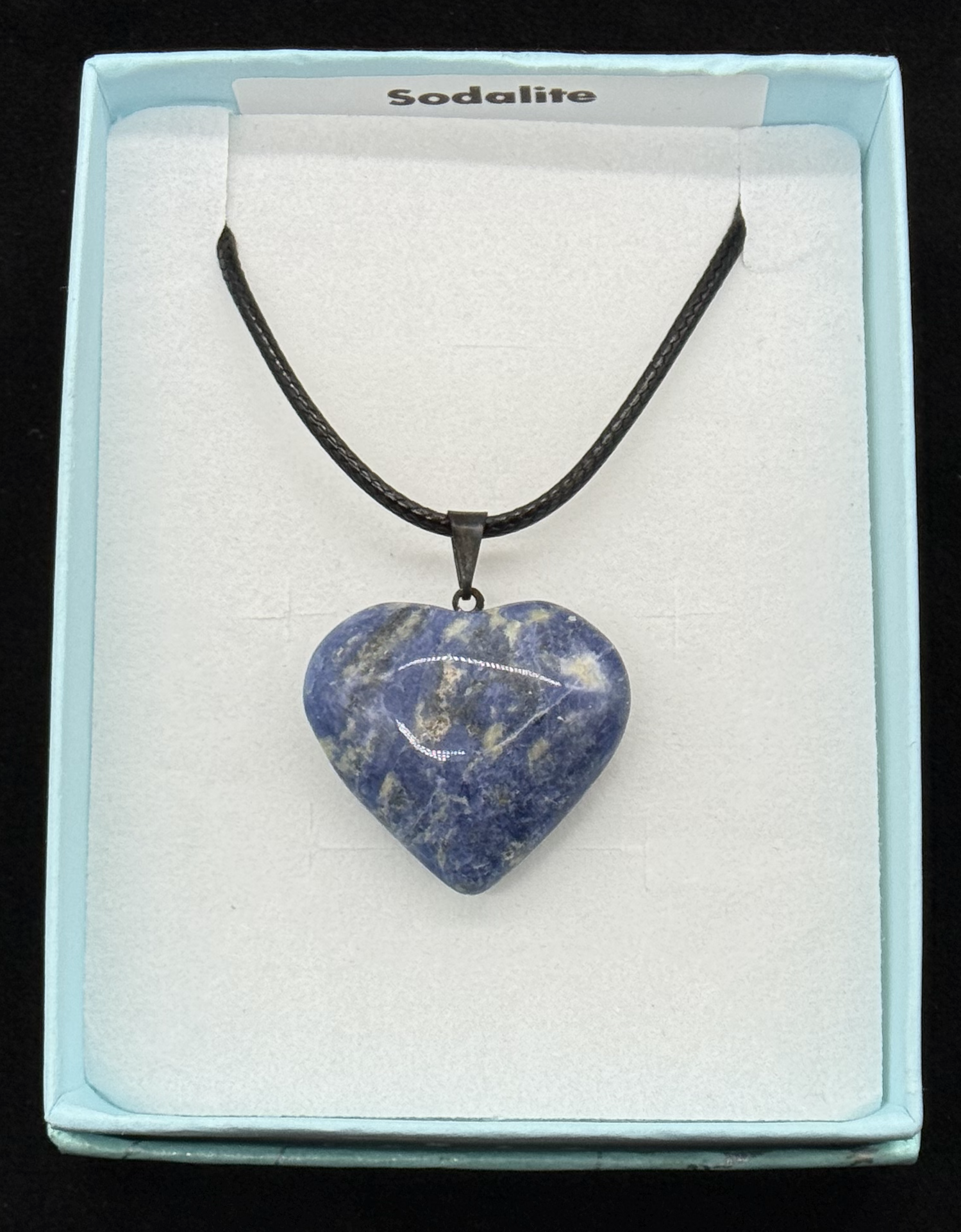 Deep blue sodalite heart pendant on a black cord, presented in a light blue gift box