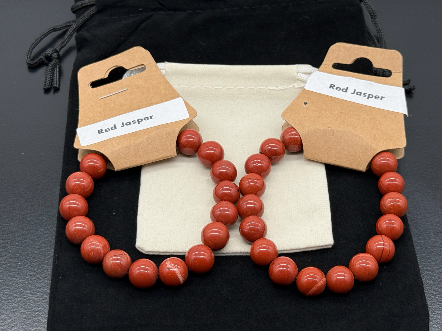 Two red jasper bead bracelets shown side by side, photographed in-studio by Robert and Angela
