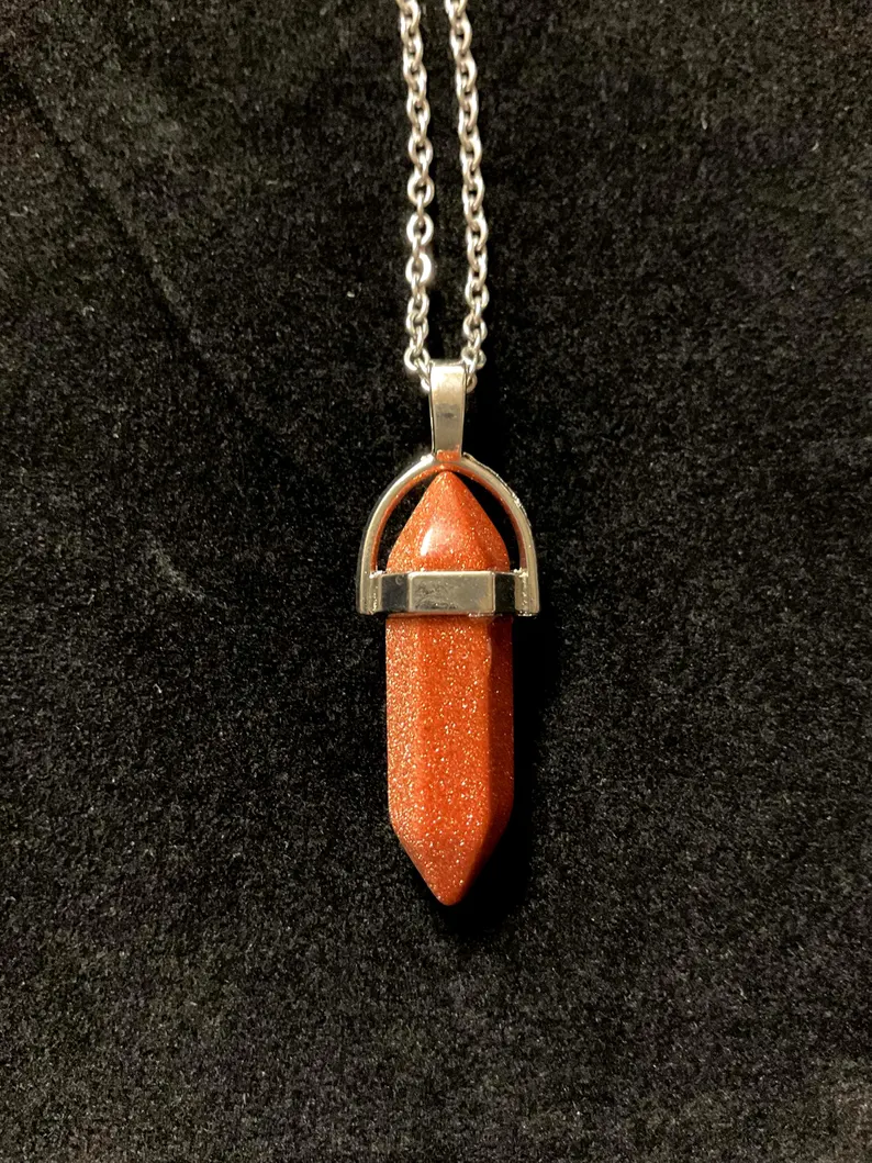 Red goldstone crystal point pendant with sparkling copper flecks in a silver setting on a stainless chain