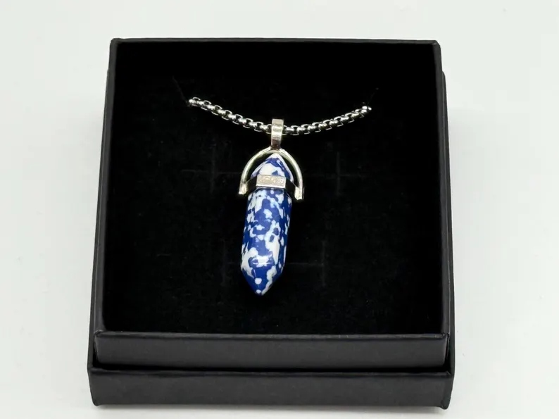 Blue and white sodalite crystal point pendant in a silver setting, boxed on black velvet