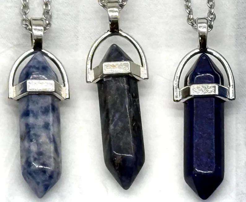 Detail view of three stone bullet pendants showing natural grain and silver caps