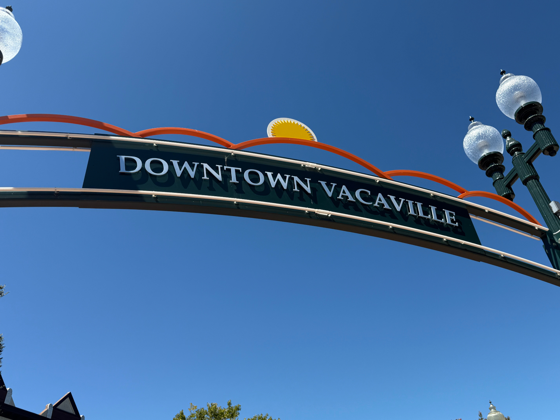 Downtown Vacaville arch sign against a bright blue sky — photo by Robert and Angela of Robert Anthony Art